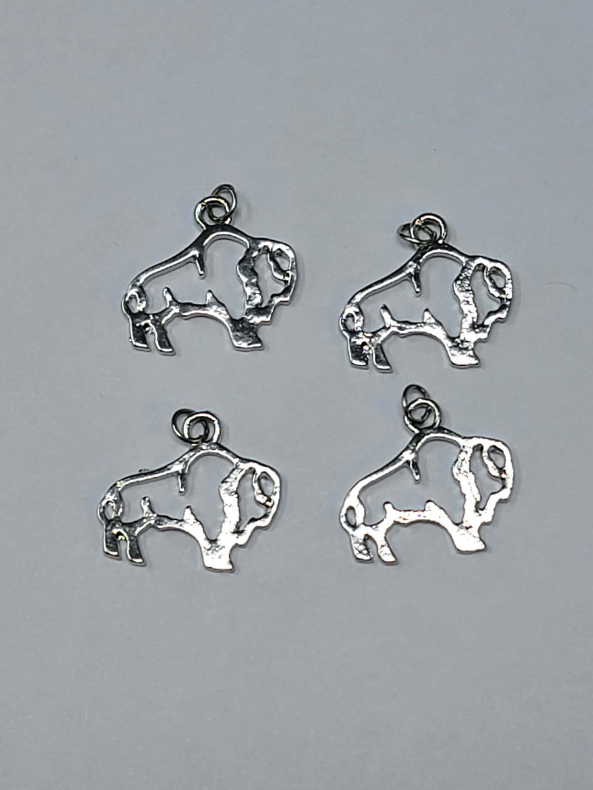 Four 17mm x 16mm silver-tone open buffalo outline charms, each with a jump ring