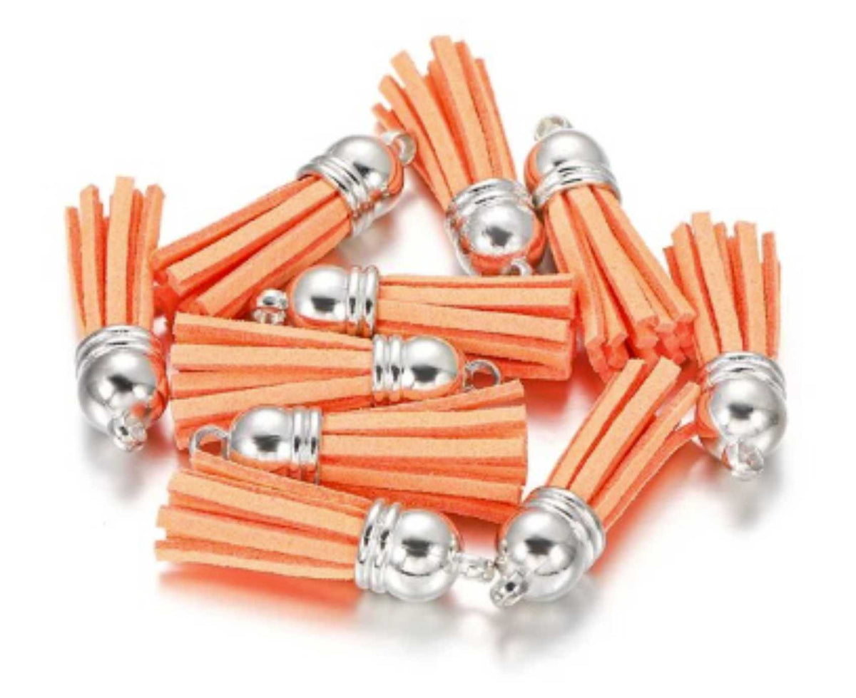 Pile of 38mm light orange leather fringe tassels with silver-tone caps and loops