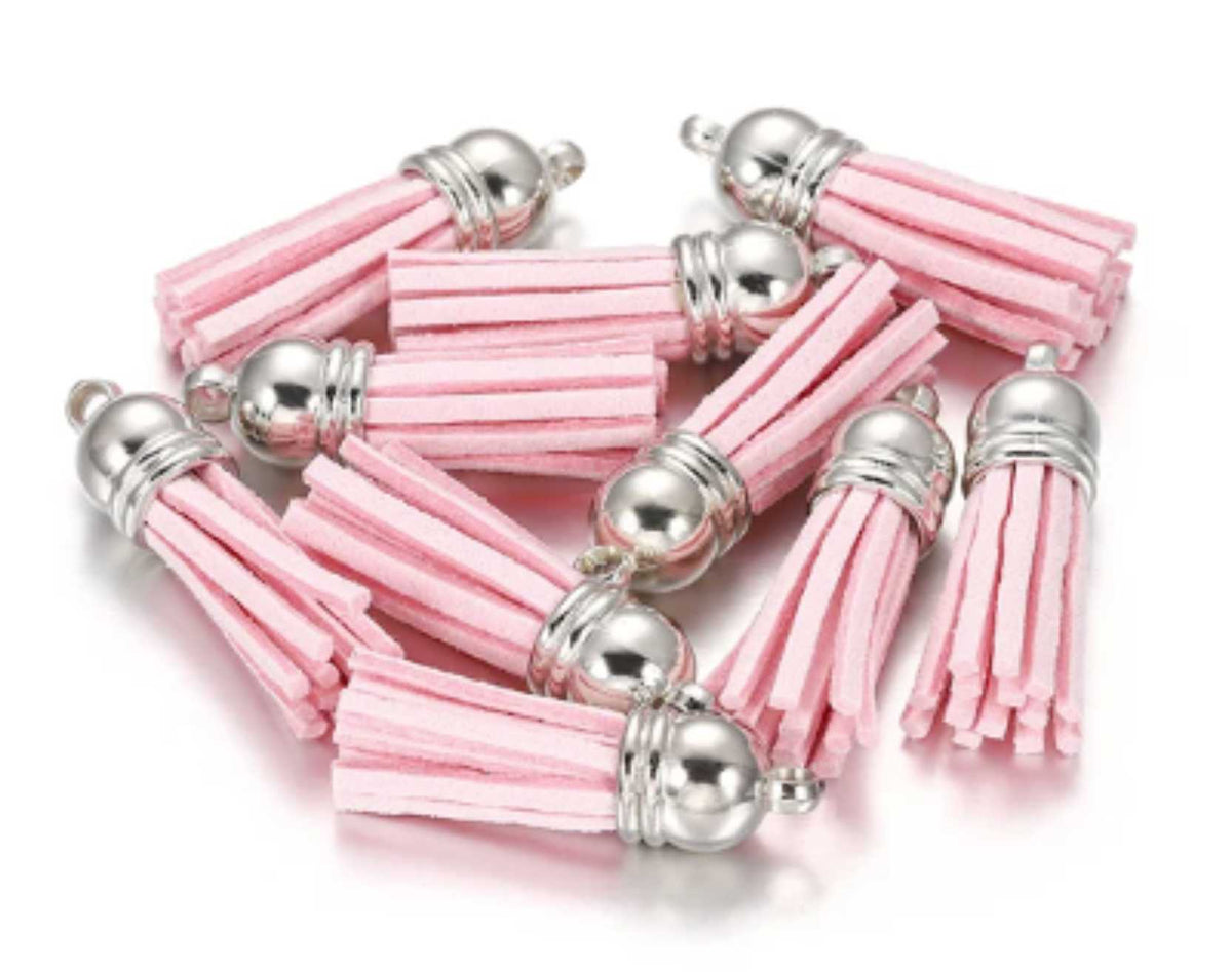 Pile of 38mm light pink leather fringe tassels with silver-tone caps and loops