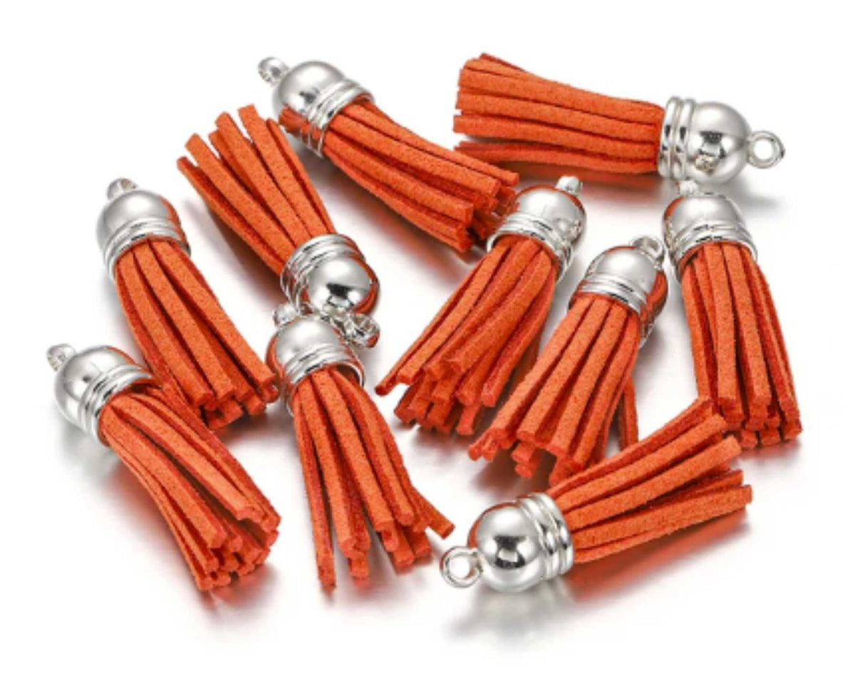 Pile of 38mm orange leather fringe tassels with silver-tone caps and loops