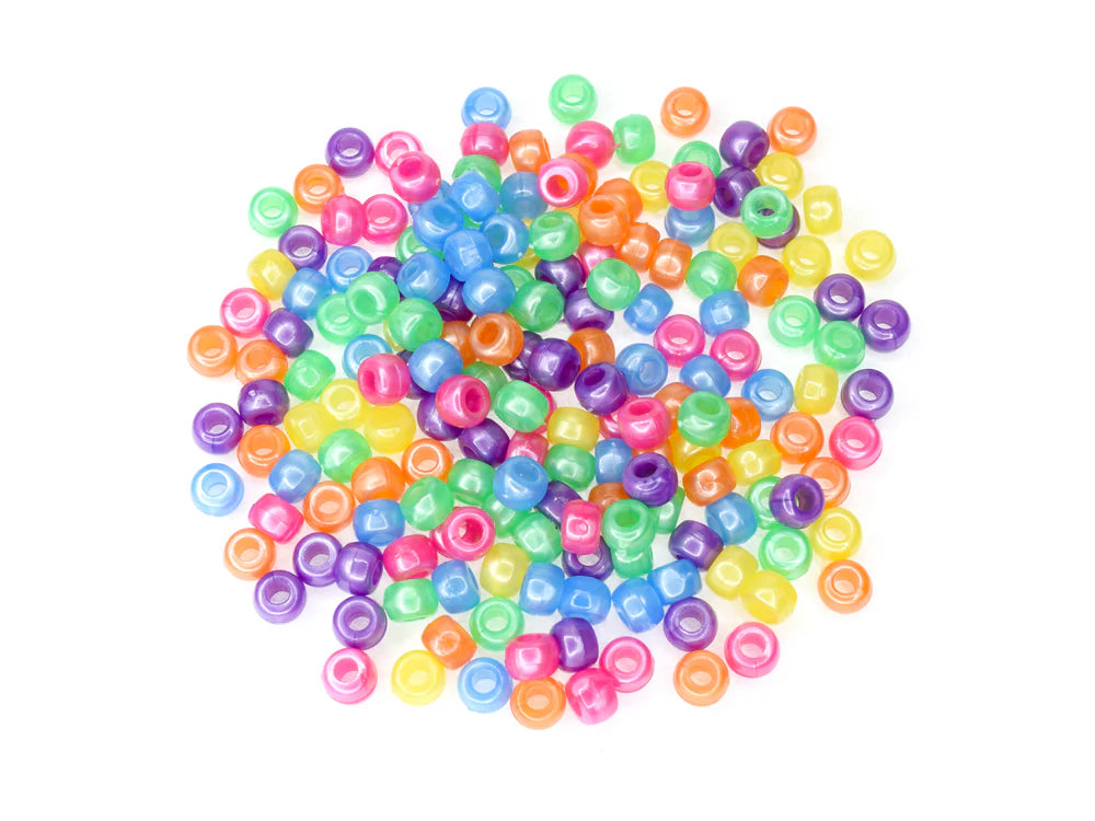 Pile of 6 x 9mm plastic pony beads in pastel pearl colours on a white background