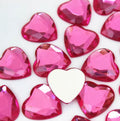 Pile of 20mm faceted pink resin heart gem cabochons (cabs), one flipped to show the flat back