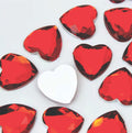 Pile of 20mm faceted red resin heart gem cabochons (cabs), one flipped to show the flat back