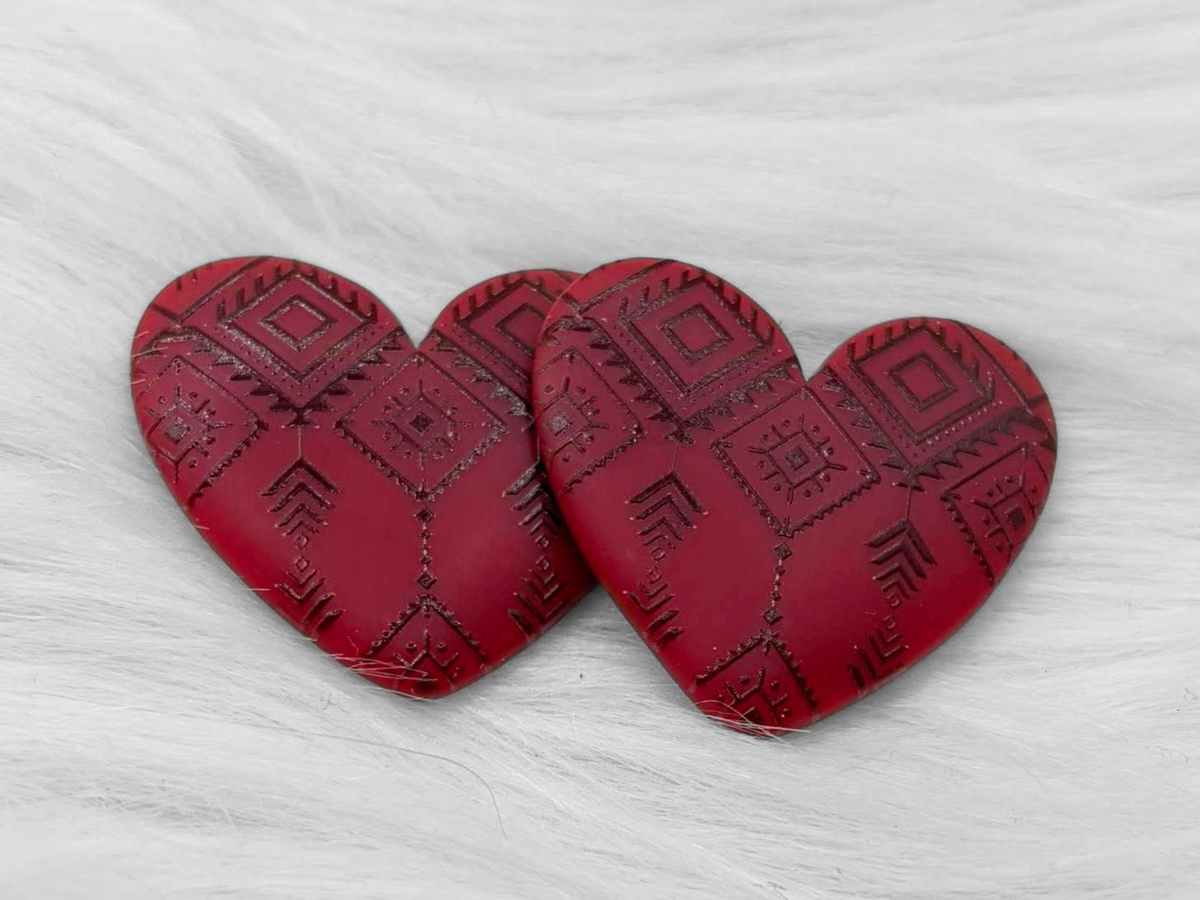 Pair of 37mm resin heart cabochons (cabs) in deep red with an embossed geometric pattern
