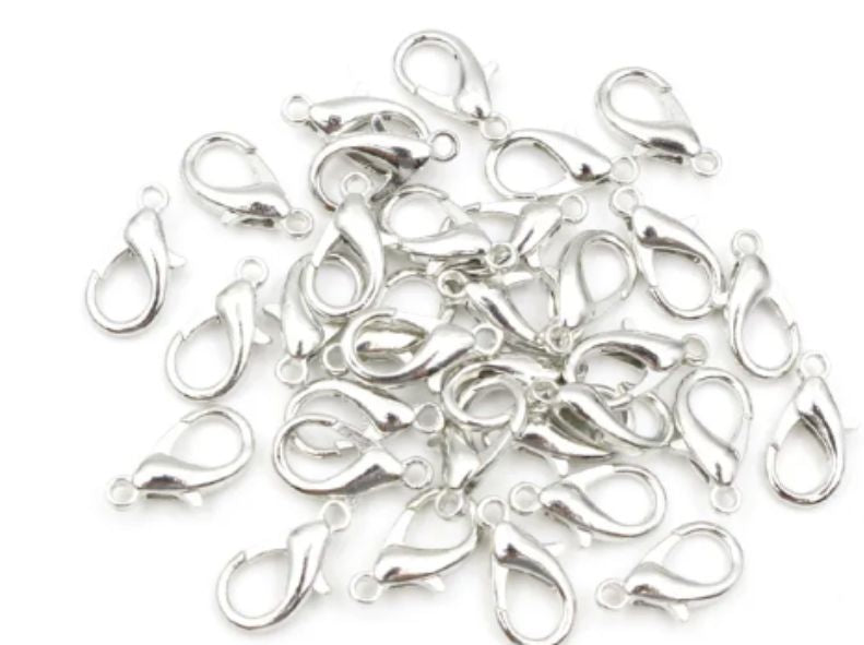 Pile of rhodium 6 x 12mm lobster clasps with trigger openings, on a white background