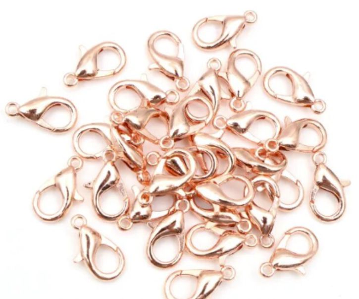 Pile of rose gold 6 x 12mm lobster clasps with trigger openings, on a white background