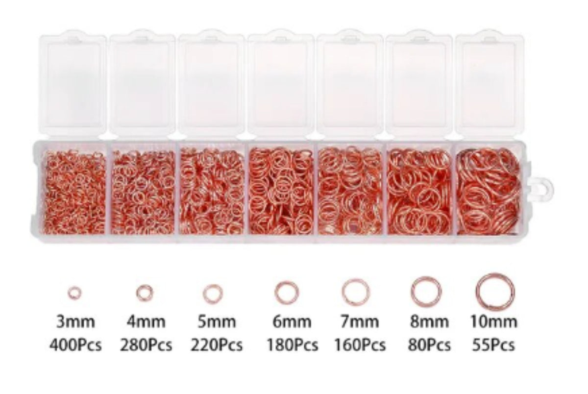 Clear divided case of rose gold jump rings in seven sizes from 3mm to 10mm, with size labels