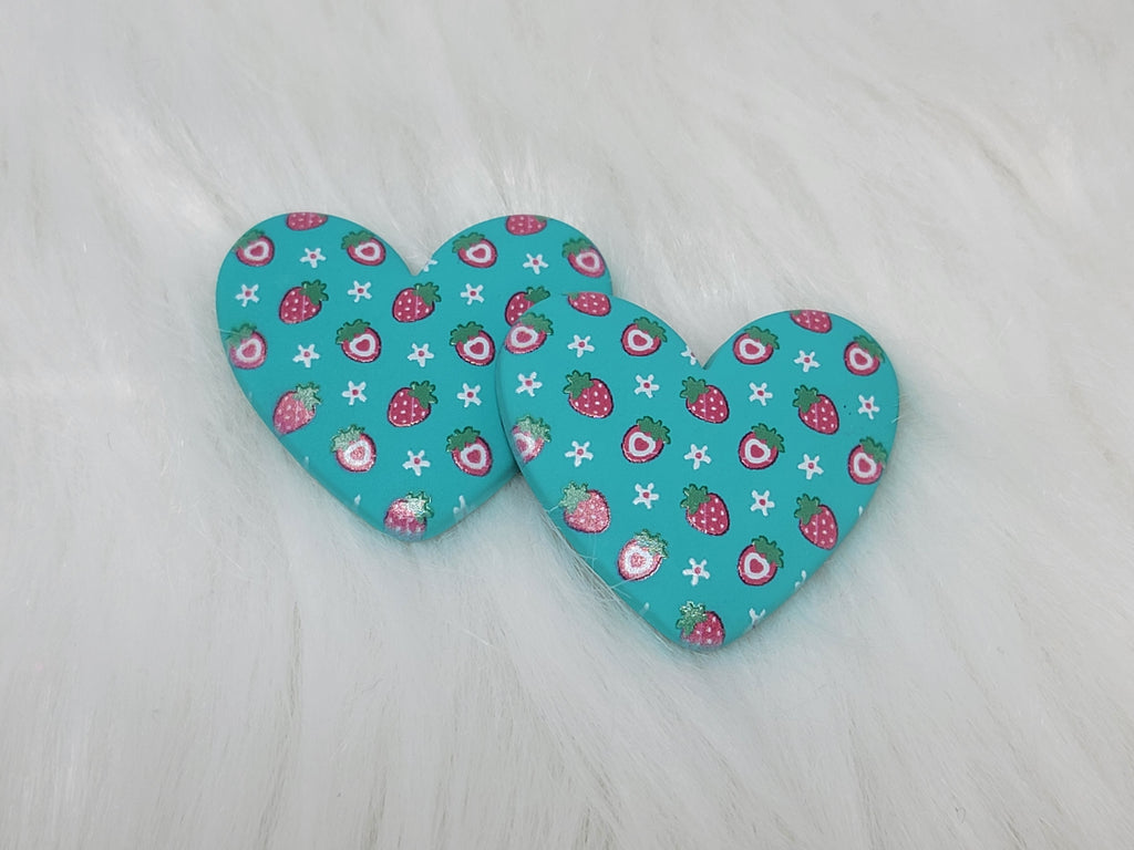 Pair of 37mm resin heart cabochons (cabs) in teal with a red strawberry and white flower pattern