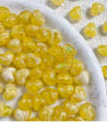 Bowl of 10 x 12mm yellow swirl heart acrylic beads with a marbled clear finish