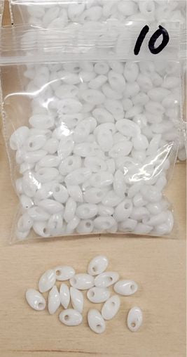Bag of long magatama beads in white marked #10, with loose beads in front