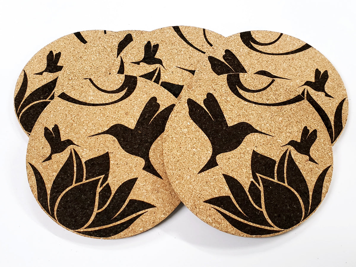 Stack of round cork coasters printed in black with hummingbirds and lotus flowers