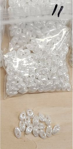 Bag of long magatama beads in white AB marked #11, with loose beads in front