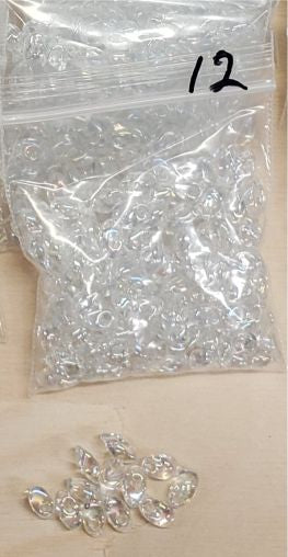 Bag of long magatama beads in crystal AB marked #12, with loose beads in front