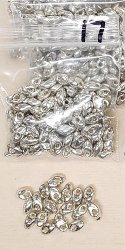 Bag of long magatama beads in chrome marked #17, with loose beads in front