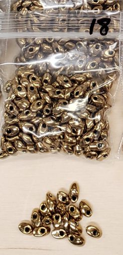 Bag of long magatama beads in KC gold marked #18, with loose beads in front