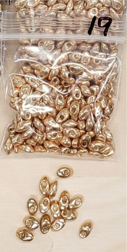 Bag of long magatama beads in bright gold marked #19, with loose beads in front