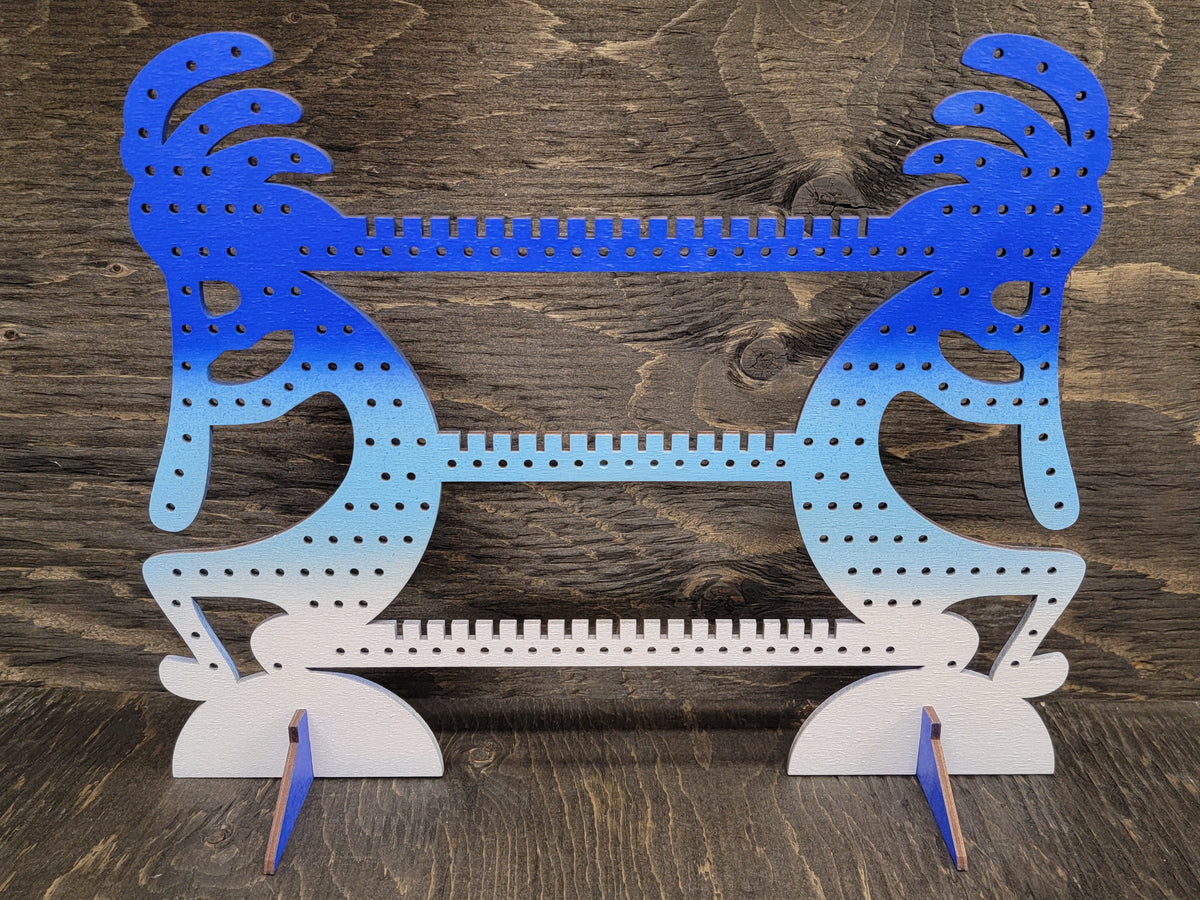 Kokapeli-shaped earring display rack with rows of holes, in blue to light blue to white