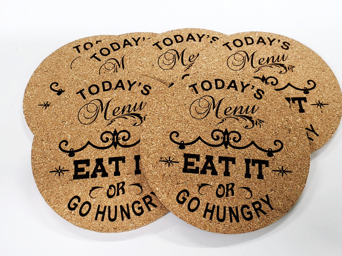 Stack of round cork coasters printed with the words 'Today's Menu: Eat It or Go Hungry'