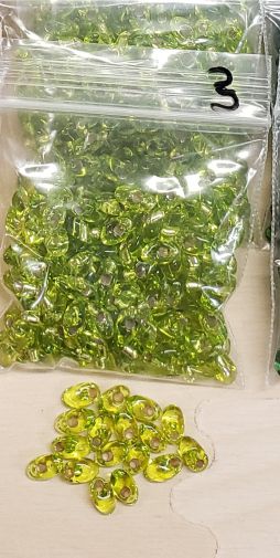 Bag of long magatama beads in lime marked #3, with loose beads in front