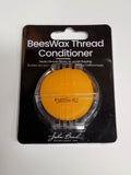 Round cake of natural beeswax thread conditioner in a John Bead blister pack