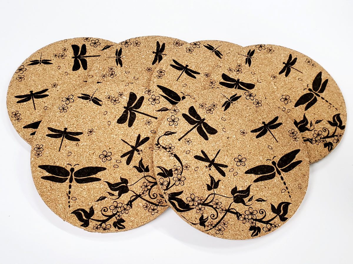 Stack of round cork coasters printed in black with a dragonfly pattern
