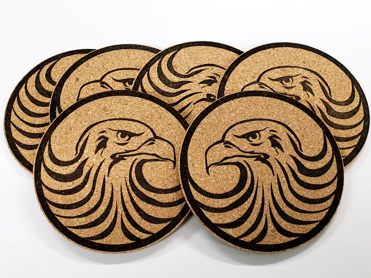 Stack of round cork coasters printed in black with a stylised eagle head in profile