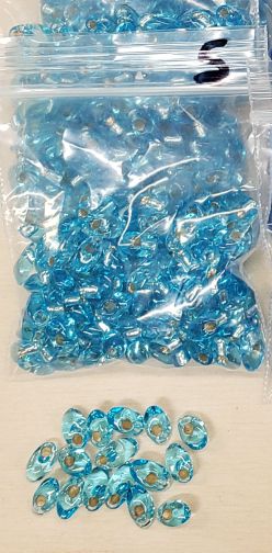 Bag of long magatama beads in lake blue marked #5, with loose beads in front
