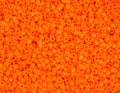 Close-up of Miyuki Delica 11/0 DB0722 cylinder beads in opaque orange