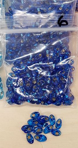 Bag of long magatama beads in royal blue marked #6, with loose beads in front