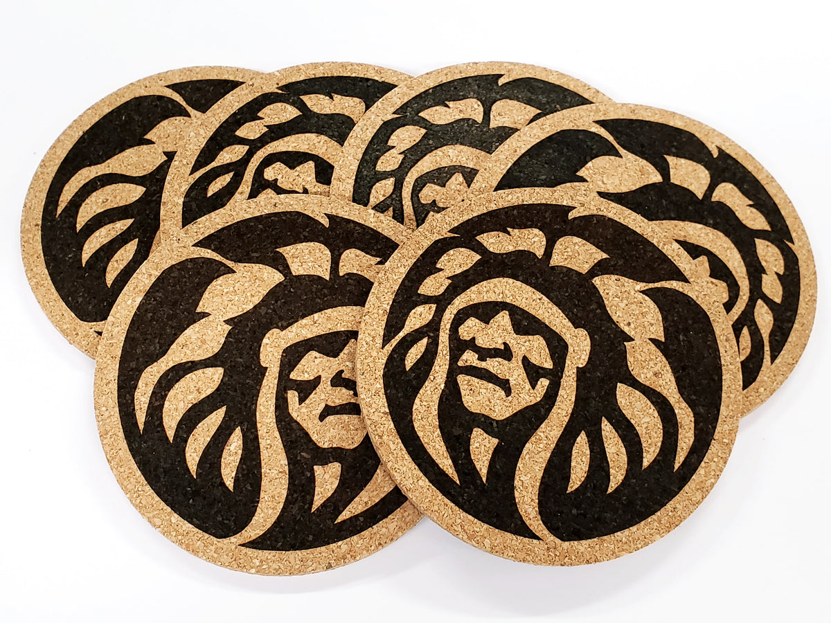 Stack of round cork coasters printed in black with a Chief B design: a profile in a feathered headdress
