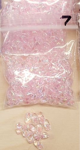 Bag of long magatama beads in pink marked #7, with loose beads in front