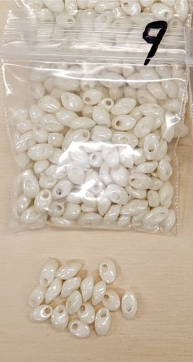 Bag of long magatama beads in eggshell marked #9, with loose beads in front