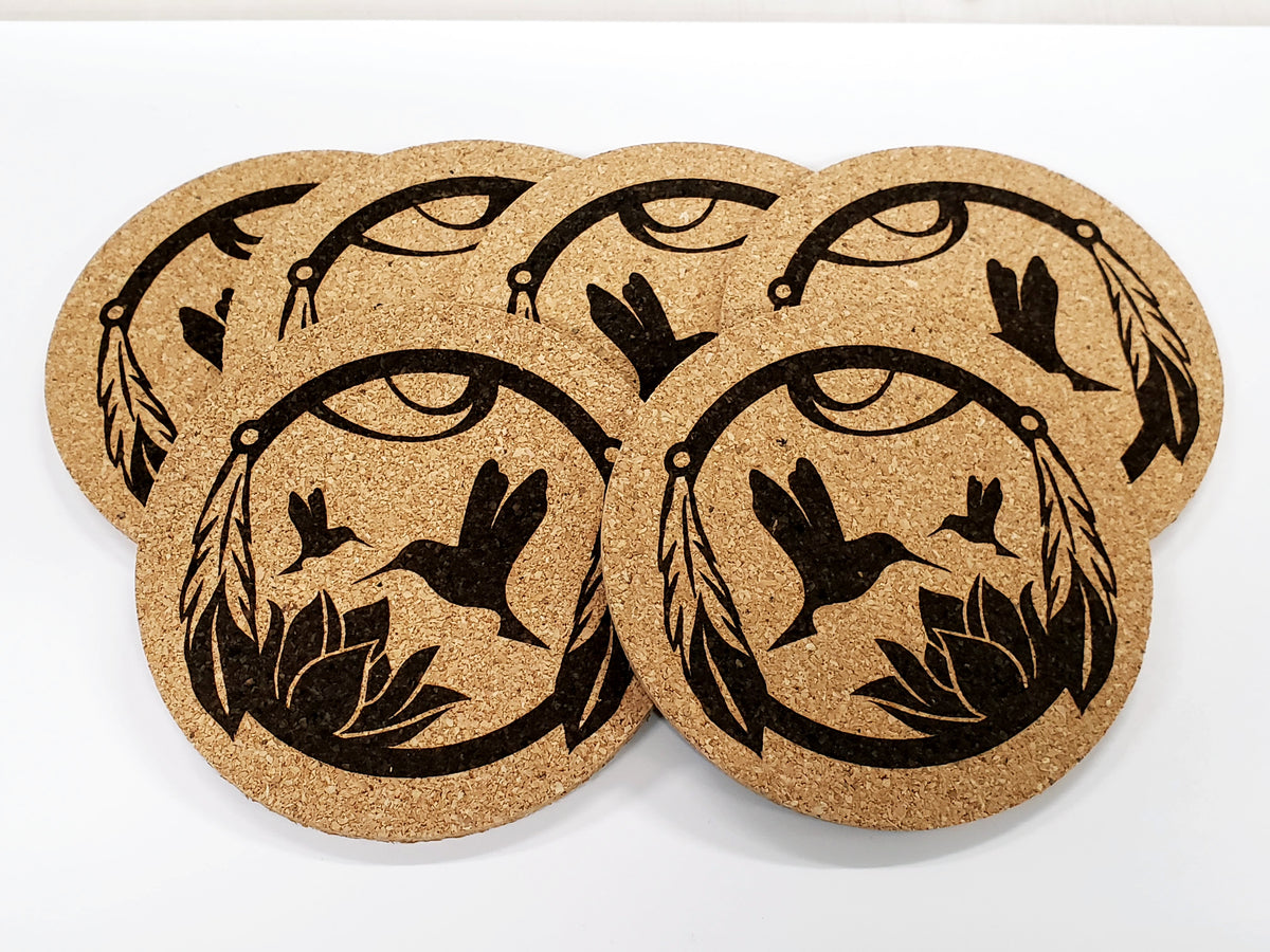 Stack of round cork coasters printed in black with hummingbirds over a flower in a ring
